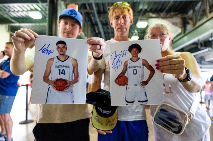 <strong>These fans hold up photographs and hats signed by Memphis Grizzlies draftees Jaylen Wells and Zach Edey at the Memphis Redbirds annual Red, White and Boom celebration game July 3, 2024.</strong> (Benjamin Naylor/The Daily Memphian)