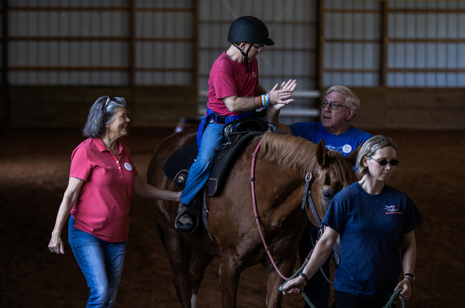 <strong>Clark Tompkins high fives one of his instructors while riding at Southern Reins Center for Equine Therapy June 20.</strong> (Patrick Lantrip/The Daily Memphian)