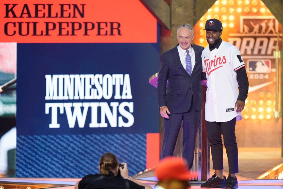 <strong>Major League Baseball Commissioner Rob Manfred, left, and Kaelen Culpepper, right, pose for a photo after Culpepper was selected 21st overall by the Minnesota Twins in the first round of the MLB baseball draft in Fort Worth, Texas, Sunday, July 14, 2024.</strong> (AP Photo/LM Otero)