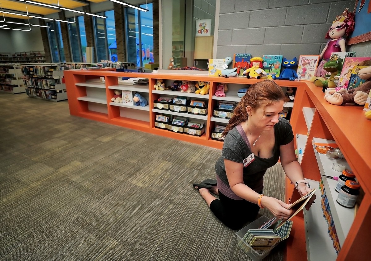<strong>Librarian Jennifer Mock organizes displays at the entrance to her new library stocked with all new books on Aug. 8, 2019&nbsp;as teachers, administrators and construction crews put the finishing touches on Germantown's new Forest Hill Elementary.&nbsp;</strong>(Jim Weber/Daily Memphian)