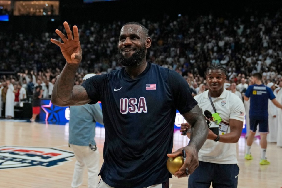 <strong>United States' LeBron James throws a signed golden ball after his team won an exhibition basketball match against Serbia at the USA Basketball Showcase, ahead of the 2024 Paris Olympic basketball tournament, in Abu Dhabi, United Arab Emirates, Wednesday, July 17, 2024.</strong> (Altaf Qadri/AP)