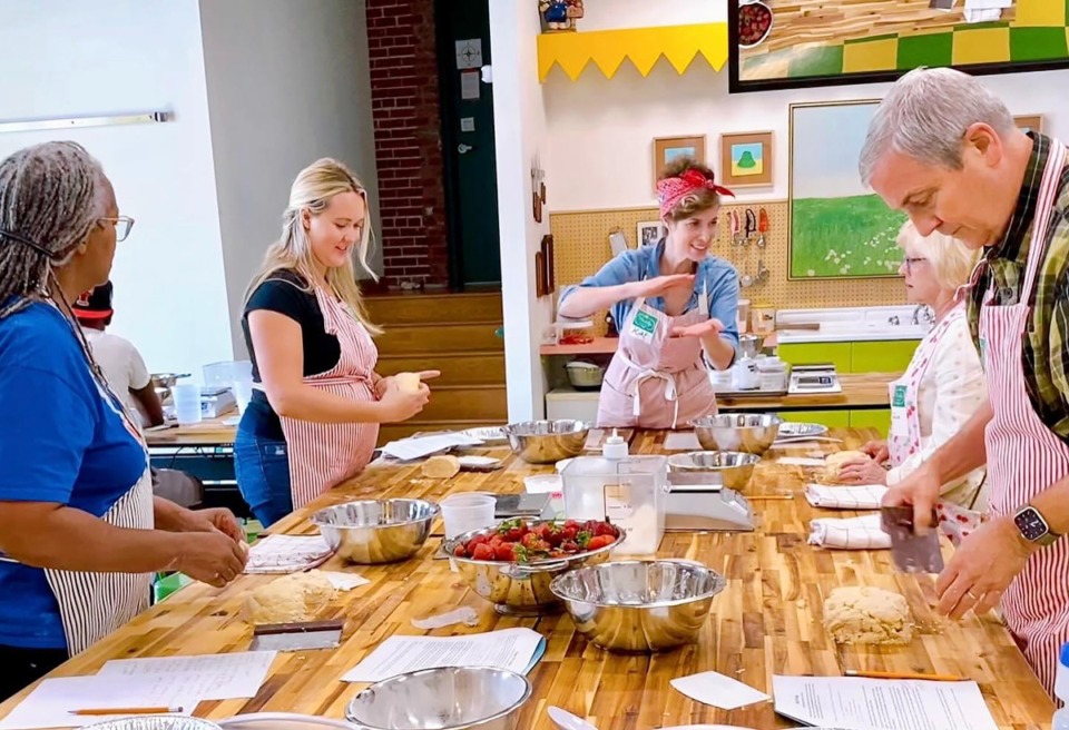 <strong>Kat Gordon (center) teaches a cooking class at her bakery Muddy's Bake Shop.</strong> (Courtesy Muddy's Bake Shop)