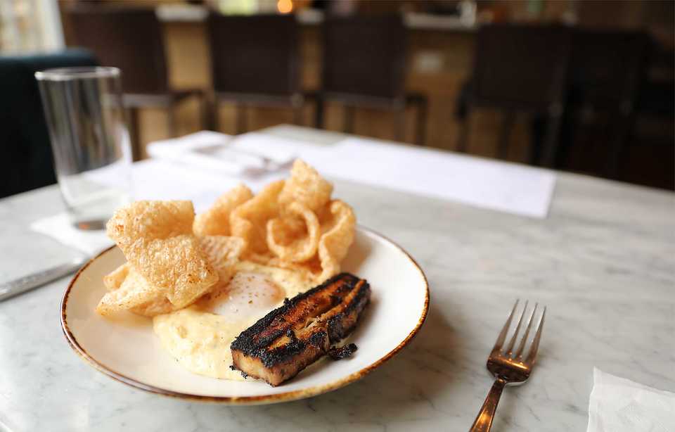 <strong>The egg is soft and runny, and served at 63 degrees in the A|M Breakfast. It&rsquo;s served atop creamy polenta with a strip of pork belly and house-made pork rinds.</strong> (Patrick Lantrip/Daily Memphian)