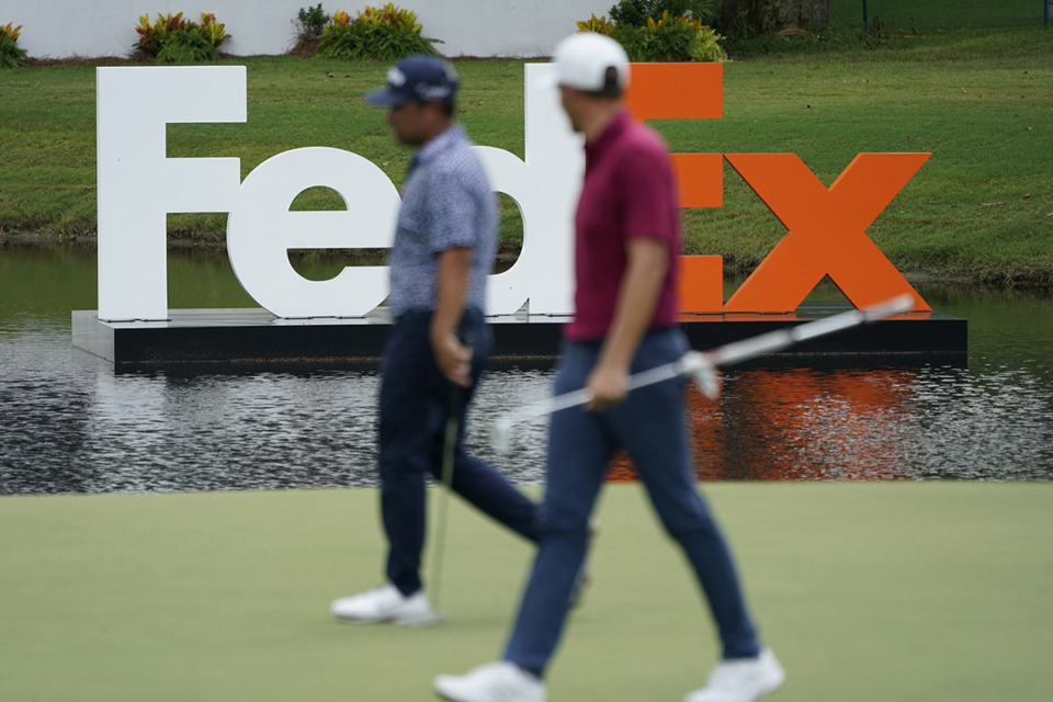 <strong>Players walks past a FedEx sign during the FedEx St. Jude Championship golf tournament at TPC Southwind.</strong> (Mark Humphrey/AP file)