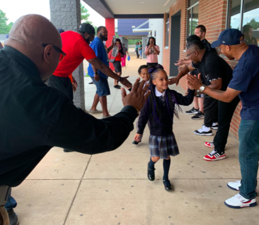 <strong>Community members in the Hickory Hill neighborhood offer cheers and high-fives to welcome students back to Power Center Academy Elementary School.</strong><span>&nbsp;(Photo courtesy of Power Center Academy)</span>