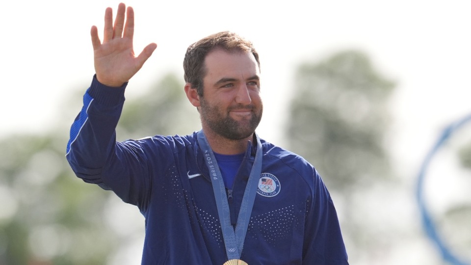 <strong>Scottie Scheffler, of the United States, waves to the crowd with his gold medal for men's golf during the medal ceremony at the 2024 Summer Olympics, Sunday, Aug. 4, 2024, at Le Golf National in Saint-Quentin-en-Yvelines, France. Scottie Scheffler, of the United States, won the gold medal with Tommy Fleetwood, of Britain, silver and Hideki Matsuyama, of Japan, the bronze.&nbsp;</strong>(Matt York/AP Photo)