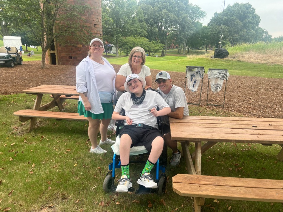 <strong>Miles Harrell, middle, watches golf near the 8th tee box at TPC Southwind. Caregiver Tabitha is on the left, mother Christine is back middle and father Tim is on the right.</strong> (Drew Hill/The Daily Memphian)