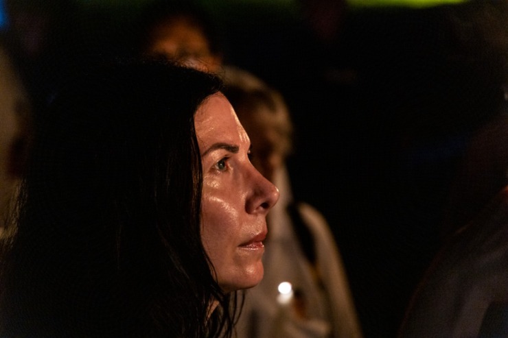 <strong>A fan, her face aglow from the light of the many candles, seems lost in the thought at the Graceland vigil.</strong> (Brad Vest/Special to The Daily Memphian)