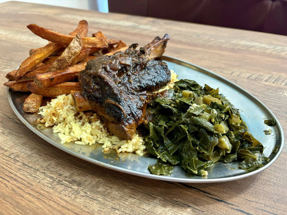 <strong>The lamb at StickEm is braised in a sweet, spicy and sticky sauce much like awaze, a staple Ethiopian sauce, and is served over yellow rice with two sides of your choice. Joshua had the collard greens and seasoned fries.</strong> (Joshua Carlucci/Special to The Daily Memphian)