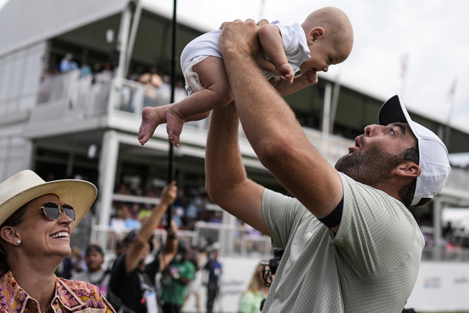 <strong>Scottie Scheffler holds his son Bennett Ezra Scheffler as his wife Meredith Scudder looks on the 18th green after Scheffler won the final round of the Tour Championship golf tournament on Sunday, Sept. 1, 2024, in Atlanta.</strong> (Mike Stewart/AP Photo)