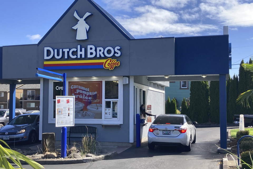 <strong>An employee of Dutch Bros in Salem, Ore., hands a drink to a customer Sept. 15, 2021.</strong> (Andrew Selsky/AP file)