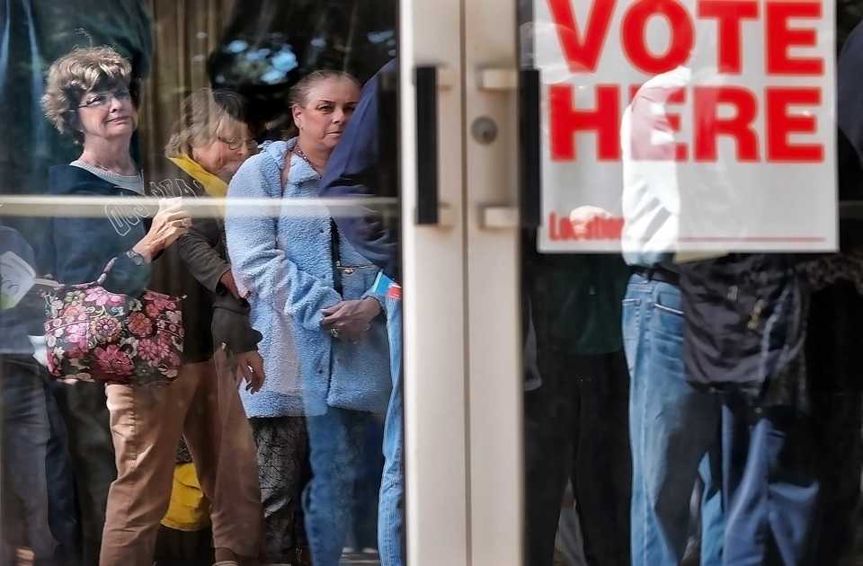 <strong>Reflected in the doors at the Agricenter, Memphians line up outside, sometimes waiting an hour and a half to cast their ballot during the first day of early voting in Shelby County on Oct. 17, 2018.</strong> (Jim Weber/Daily Memphian)
