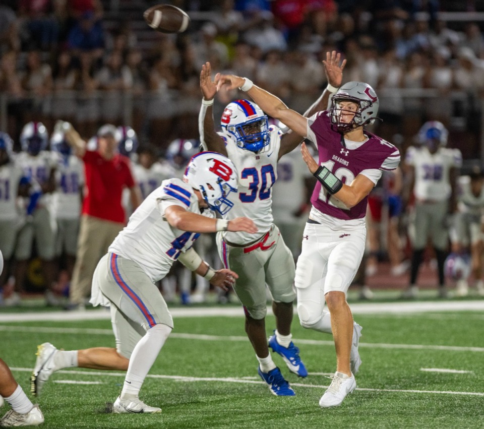 <strong>Collierville quarterback Grant Troutman (12) releases the ball as Bartlett's Austin Howard (30) and Brad Fears (43) put pressure on him in Friday's game at Collierville High School, Sept. 6, 2024.</strong> (Greg Campbell/Special to The Daily Memphian)