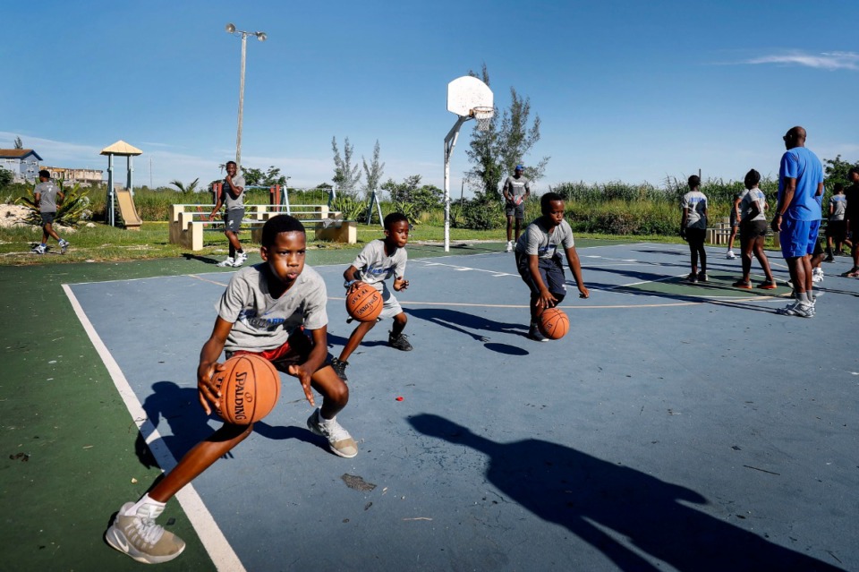 <strong>Raynor Russell, 14, (left) shows his dribbling skills along with fellow campers during a basketball camp with Memphis Tigers coaches and players in the Bozine Town area of Nassau, Bahamas, Aug. 16, 2019.</strong> (Mark Weber/Daily Memphian)