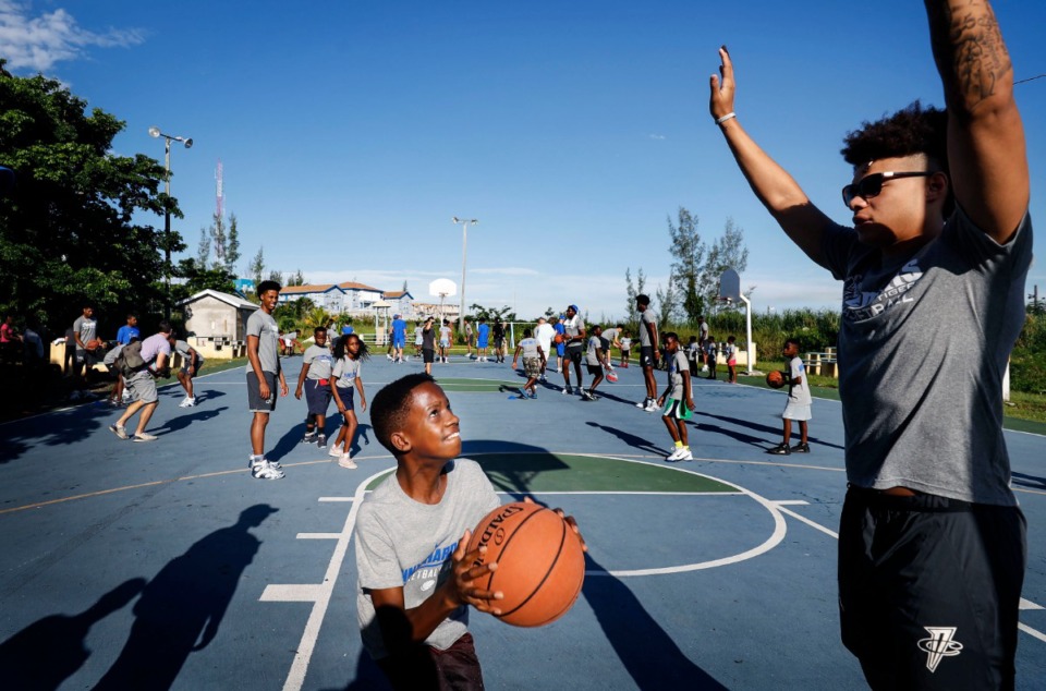 <strong>Raynor Russell, 14, (left) drives for a layup against Memphis Tigers player Lester Quinones (right) during a basketball camp with local youth in the Bozine Town area of Nassau, Bahamas, Aug. 16, 2019.</strong> (Mark Weber/Daily Memphian)