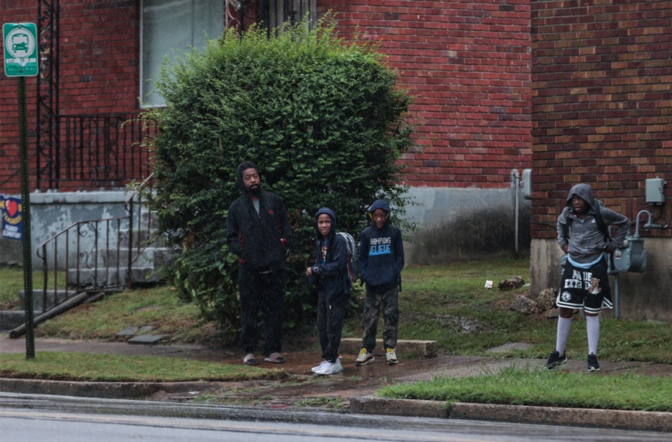 <strong>Parents and kids from Vollintine Elementary School wait at a bus stop after getting let out of inclement weather Sept. 12, 2024.</strong> (Patrick Lantrip/The Daily Memphian)