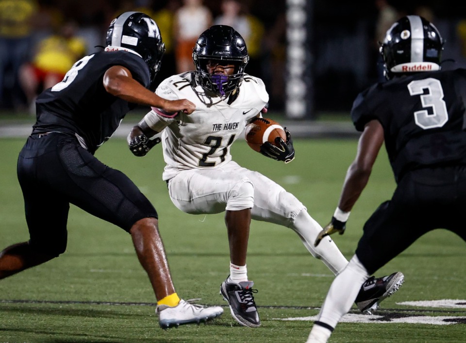 <strong>Whitehaven running back Christopher Talley (middle) makes a run against the Houston defense during action on Friday, Sept. 20, 2024.</strong> (Mark Weber/The Daily Memphian)