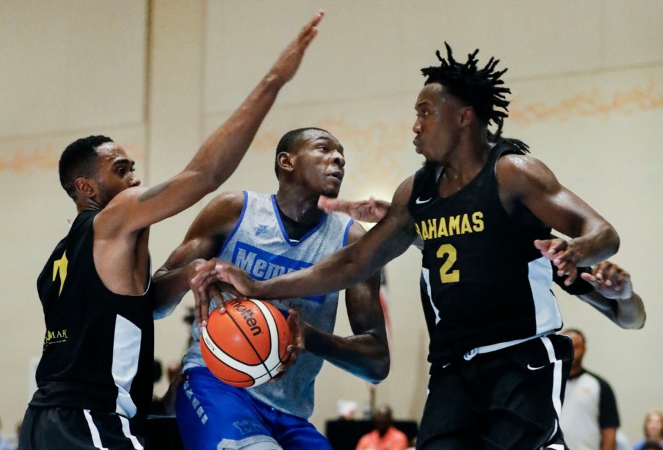 <strong>Memphis Tigers forward Lance Thomas (middle) is fouled while driving the lane against Bahamas National Team defenders D'Shon Taylor (left) and Jaron Cornish (right) during action in their exhibition game in Nassau, Bahamas, Saturday, August 17, 2019.</strong> (Mark Weber/Daily Memphian)