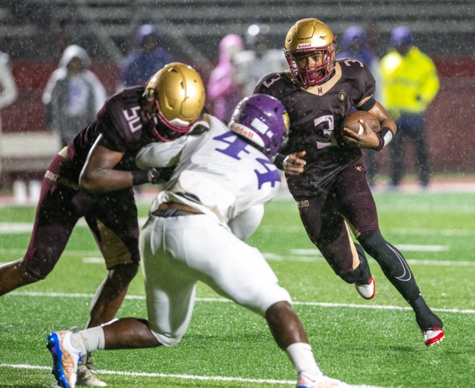 <strong>Melrose quarterback Tavarco Jackson gets a crucial block from offensive lineman Brendaun Milligan against Southwind's Lonnie Kimble, to make a first down in a steady rain. Southwind came from behind in the second half to win 8-6.</strong> (Greg Campbell/Special to The Daily Memphian)