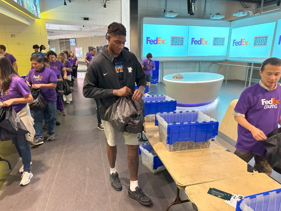 <strong>Memphis center Dain Dainja helps stuff bags for U.S. troops Wednesday, Oct. 2, 2024 at FedExForum during a FedEx Cares community outreach event.</strong> (Parth Upadhyaya/The Daily Memphian)