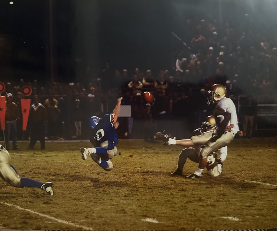 <strong>MUS standout Derek Clenin (in blue) blocks the game-tying extra point by CBHS in 2002 to preserve the Owls' 28-27 victory.</strong> (Courtesy Kristen Clenin)