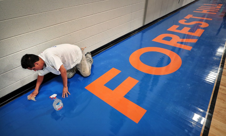 <strong>Kevin Flores puts the finishing touches on the gymnasium floor at Germantown's new Forest Hill Elementary. A potential land swap between the Germantown Municipal School District and the city has stalled. The proposed swap would give the school district space for softball fields in the city-owned Houston Levee Park in exchange for 15 acres at Forest Hill, where the city wants to place a water tower.</strong> (Jim Weber/Daily Memphian)