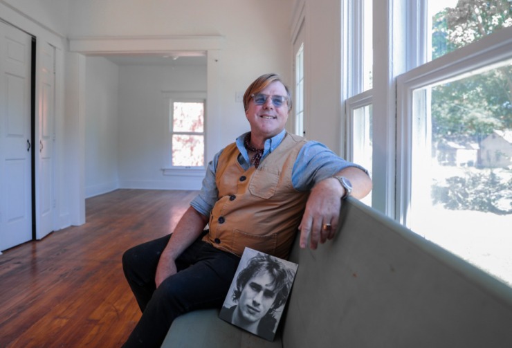 David Lorrison poses with a picture of Jeff Buckley at the site of his new Airbnb, which is the former house of the musician Oct. 16, 2024. (Patrick Lantrip/The Daily Memphian)