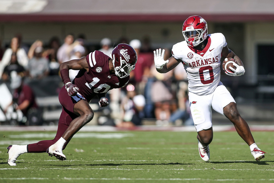 <strong>Arkansas running back Braylen Russell (0) prepares to stiff arm Mississippi State safety Corey Ellington (10) during the second second half of an NCAA college football game in Starkville, Miss., Oct. 26.</strong> (James Pugh/AP file)