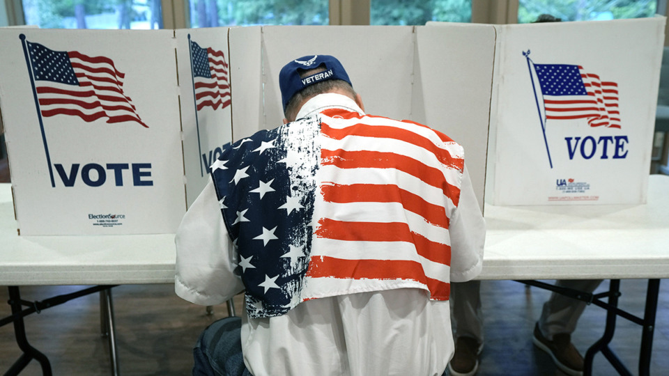 <strong>A patriotic voter sits at a voting kiosk and selects his choices in a party primary in Jackson, Miss., Tuesday, Aug. 8, 2023.</strong>&nbsp;(Rogelio V. Solis/AP file)