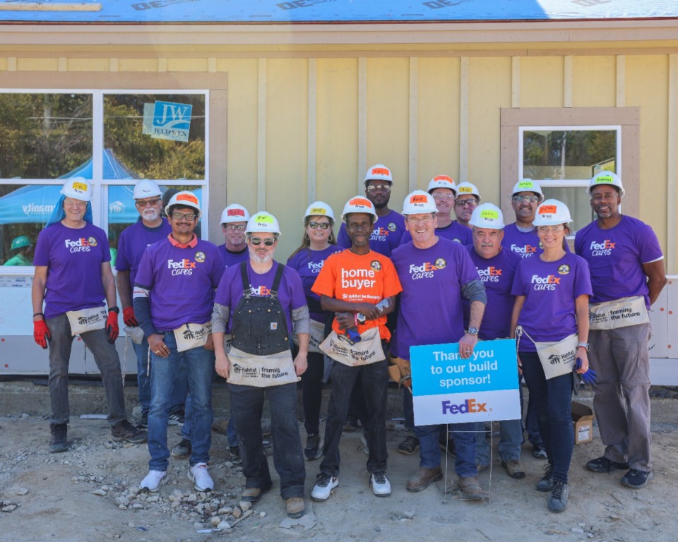 <strong>Cedric Simpson, 49, stands with FedEx volunteers who helped him cut siding for his new home in North Memphis this month as part of a Habitat for Humanity home construction project. The Memphis Police Department is scheduled to help build Simpson's home, as well as four others, on Saturday, Nov. 2.</strong>&nbsp; (Julia Baker/The Daily Memphian)