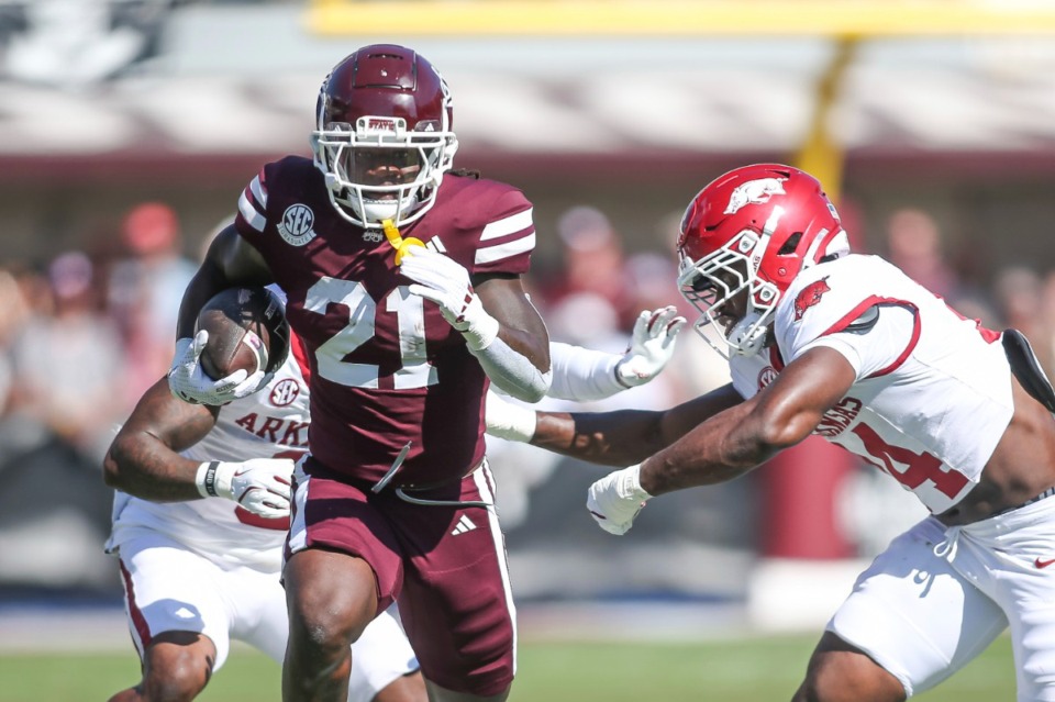 <strong>Mississippi State running back Davon Booth (21) runs for a first down against Arkansas linebacker Stephen Dix Jr. (14) during the first half of an NCAA college football game in Starkville, Miss., Saturday, Oct. 26, 2024. Arkansas won 58-25.</strong> (AP Photo/James Pugh)