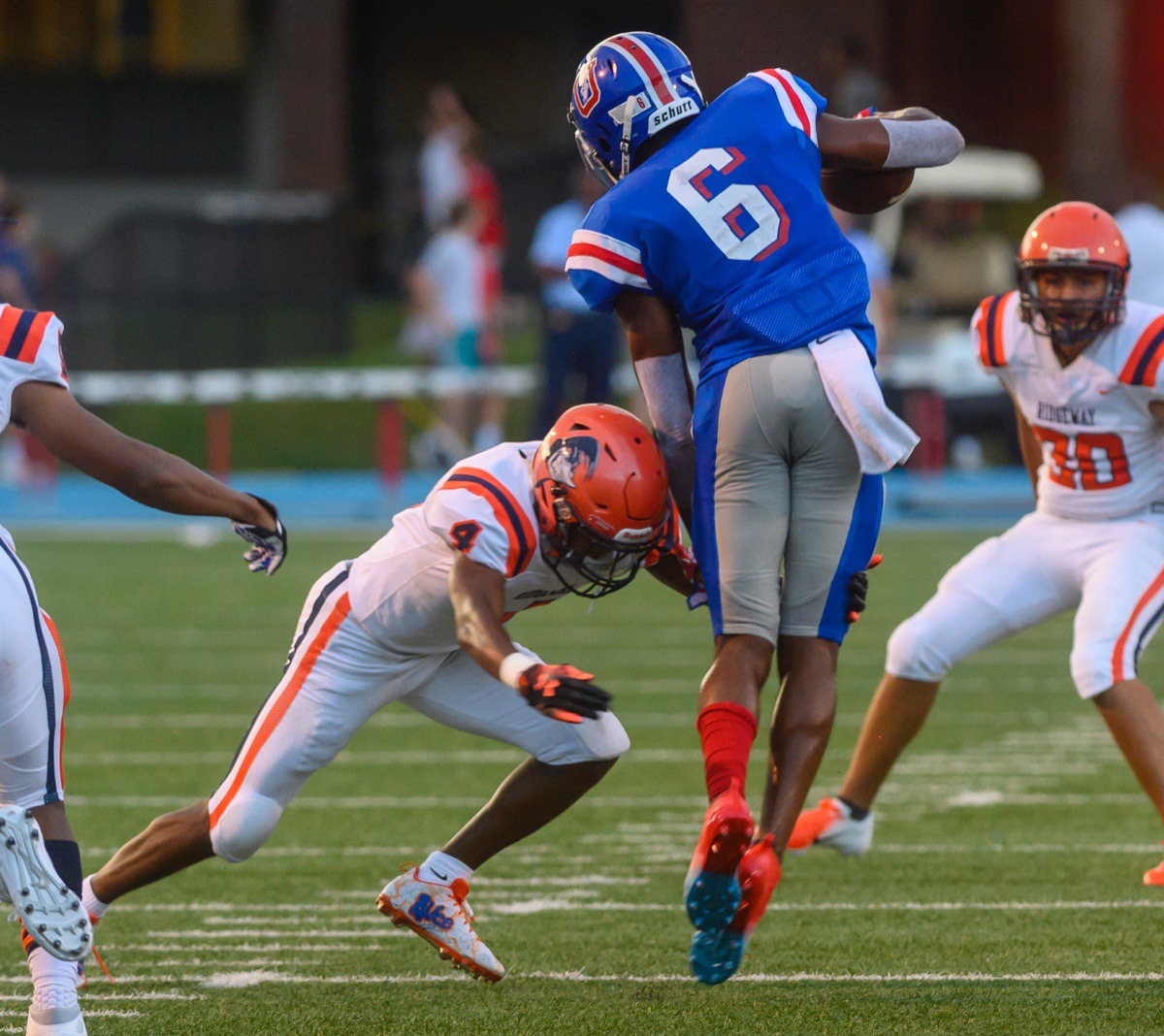 <strong>Ridgeway sophomore Quintarrius Ayers (center, in orange) tackles MUS wide receiver Roderic Lewis &nbsp;(6) in the open during Friday night's contest at MUS.</strong> (Greg Campbell/Special to the Daily Memphian)