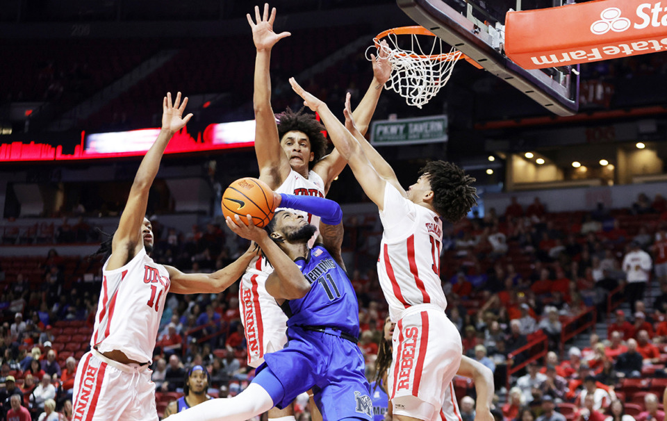 <strong>Memphis guard Tyrese Hunter (11) takes a shot while being defended by UNLV guard Jaden Henley, left, forward Jalen Hill, center, and guard Dedan Thomas Jr. (11) during the first half of an NCAA college basketball game Saturday, Nov. 9, in Las Vegas.</strong> (Steve Marcus/Las Vegas Sun via AP file)