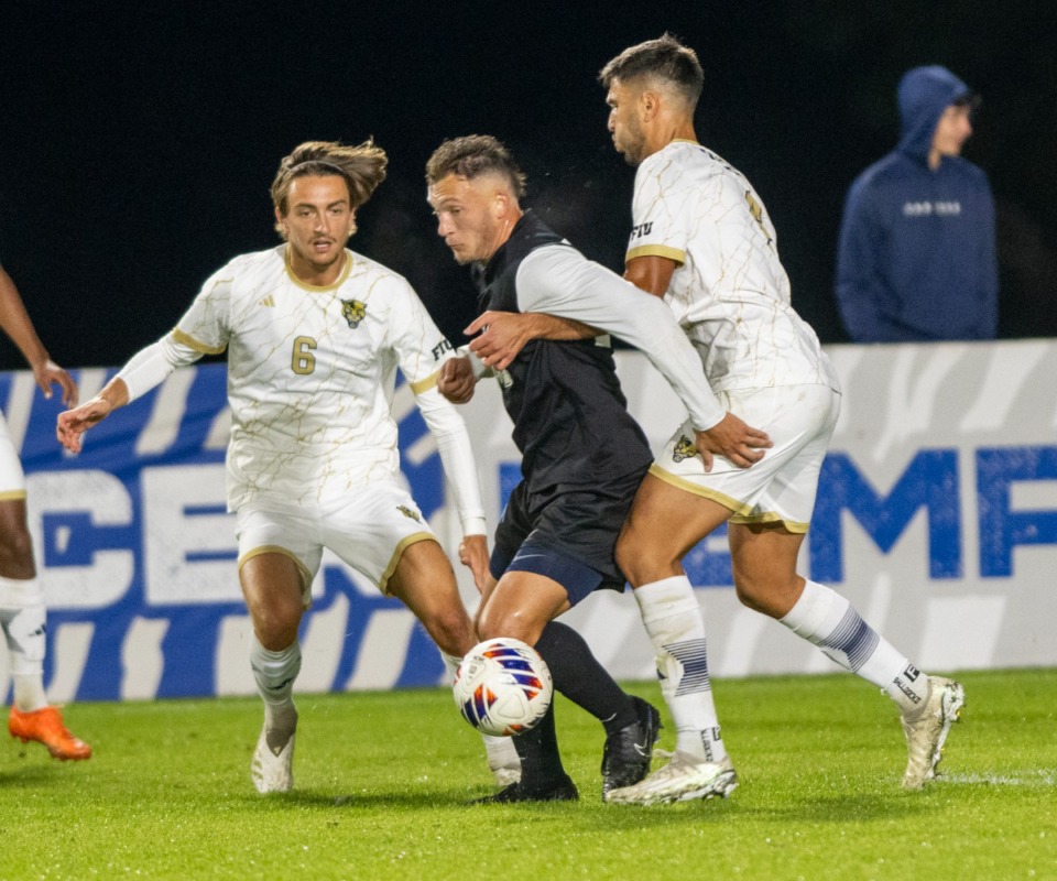 <strong>Memphis midfielder, Brody Conley, is held back by Florida International's David Houja in the semi-final match Thursday at the University of Memphia South Campus. Number 1 seed Memphis was defeated by Florida International University 3-1.</strong> (Greg Campbell/Special for The Daily Memphian)