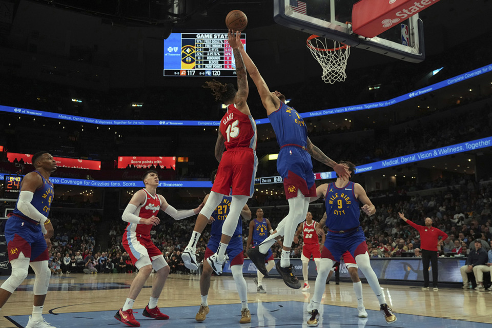 <strong>Memphis Grizzlies' Brandon Clarke (15) and Denver Nuggets' Michael Porter Jr. (1) reach for a rebound in the first half of an NBA basketball game Sunday, Nov. 17, 2024, in Memphis.</strong> (Mark Humphrey/AP Photo)