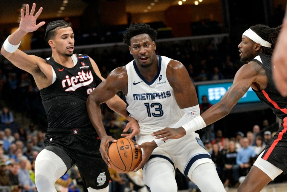 <strong>Memphis Grizzlies forward Jaren Jackson Jr. (13) takes the ball between Portland Trail Blazers forwards Toumani Camara, left, and Jerami Grant (9) Monday, Nov. 25, 2024.</strong> (Brandon Dill/AP)