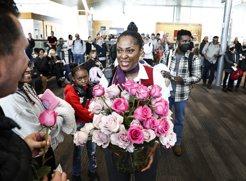 <strong>Delta Air Lines customer service expert Beverly Becton (middle) hands out roses to a customer before their flight to Atlanta. Becton, from time to time, will hand out flowers to customers celebrating an anniversary, birthday or even a pet&rsquo;s birthday.</strong> (Mark Weber/The Daily Memphian)