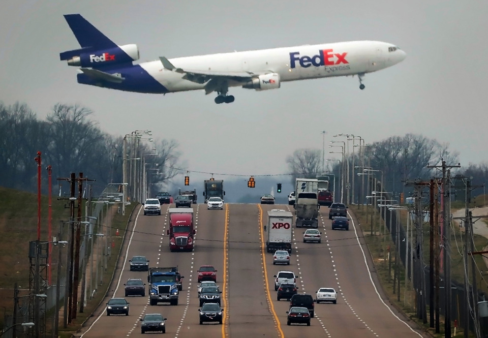 <strong>A FedEx plane passes low over Shelby Drive as it lands at Memphis International Airport. Since FedEx stopped carrying the U.S. Mail in late September, Memphis International is seeing 60 fewer planes landing a day.</strong> (Jim Weber/The Daily Memphian file)