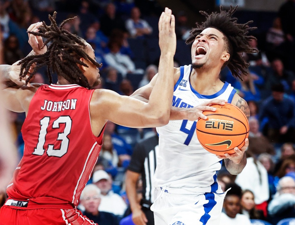 <strong>University of Memphis guard PJ Haggerty (right) drives the lane against Arkansas State defender Kameron Johnson (left) on Sunday, Dec. 8, 2024.</strong> (Mark Weber/The Daily Memphian)