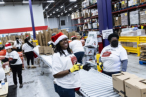 <strong>Erika Henderson, center, helps during the Team Max food giveaway at the Mid-South Food Bank.</strong> (Brad Vest/Special to The Daily Memphian)