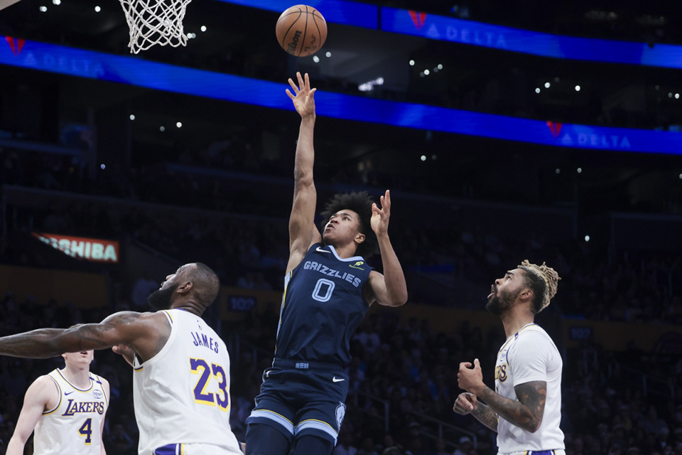 <strong>Memphis Grizzlies forward Jaylen Wells (0) shoots as Los Angeles Lakers guard D'Angelo Russell and forward LeBron James (23) watch during the first half of an NBA basketball game, Sunday, Dec. 15, 2024, in Los Angeles.</strong> (Jessie Alcheh/AP Photo)