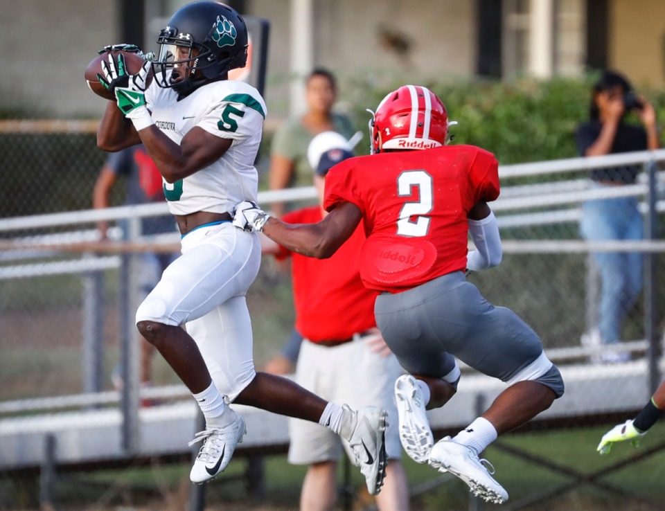 <strong>Cordova defender Kristopher Williams (left) grabs an interception in front of Germantown receiver Duane Akon (right) Friday, Aug. 30.</strong> (Mark Weber/Daily Memphian)
