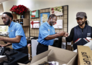 <strong>Thermon Knighten, middle, owns the UPS store on Exeter Road in Germantown, where he will perform an occasional marriage.</strong> (Mark Weber/The Daily Memphian)