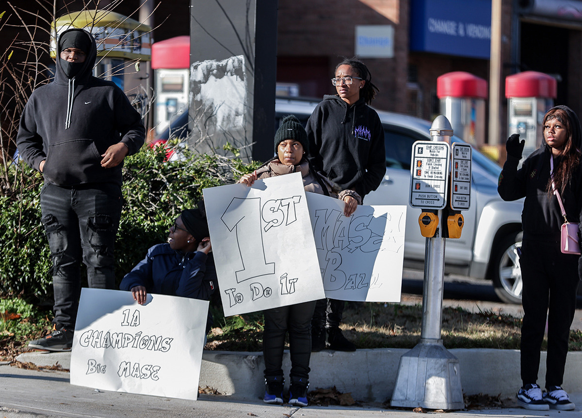 <strong>Onlookers show signs of support as the MASE football team parades down Poplar Avenue celebrating the school's first state championship in football Dec. 20.</strong> (Patrick Lantrip/The Daily Memphian)