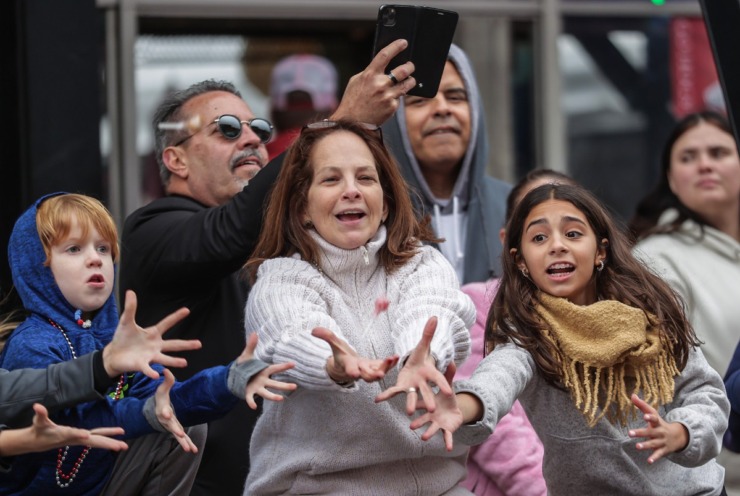 <strong>Fans stretch to catch flying candy during the AutoZone Liberty Bowl Parade Dec. 26, 2024.</strong> (Patrick Lantrip/The Daily Memphian)