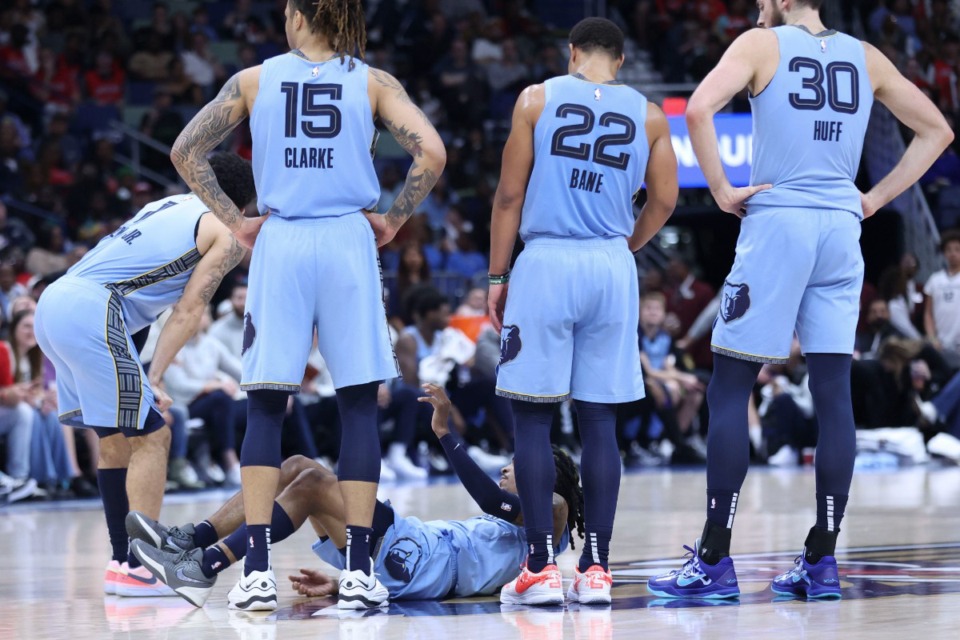 <strong>Members of the Memphis Grizzlies surround guard Ja Morant (12) as he lies on the court after being injured as the result of a hard pick in the second half of an NBA basketball game against the New Orleans Pelicans in New Orleans, Friday, Dec. 27, 2024.</strong> (Peter Forest/AP)