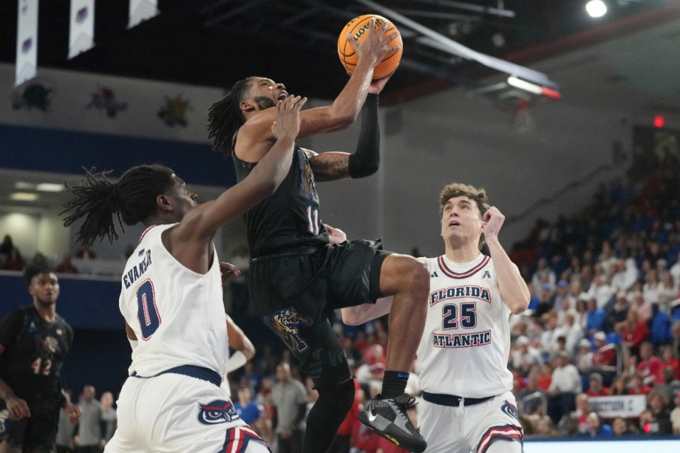 <strong>Memphis guard Tyrese Hunter (11) drives to the basket over Florida Atlantic guards Ken Evans Jr. (0) and Niccolo Moretti (25) on Thursday, Jan. 2, 2025, in Boca Raton, Fla. Huner led the Tigers with 20 points.</strong> (Marta Lavandier/AP)