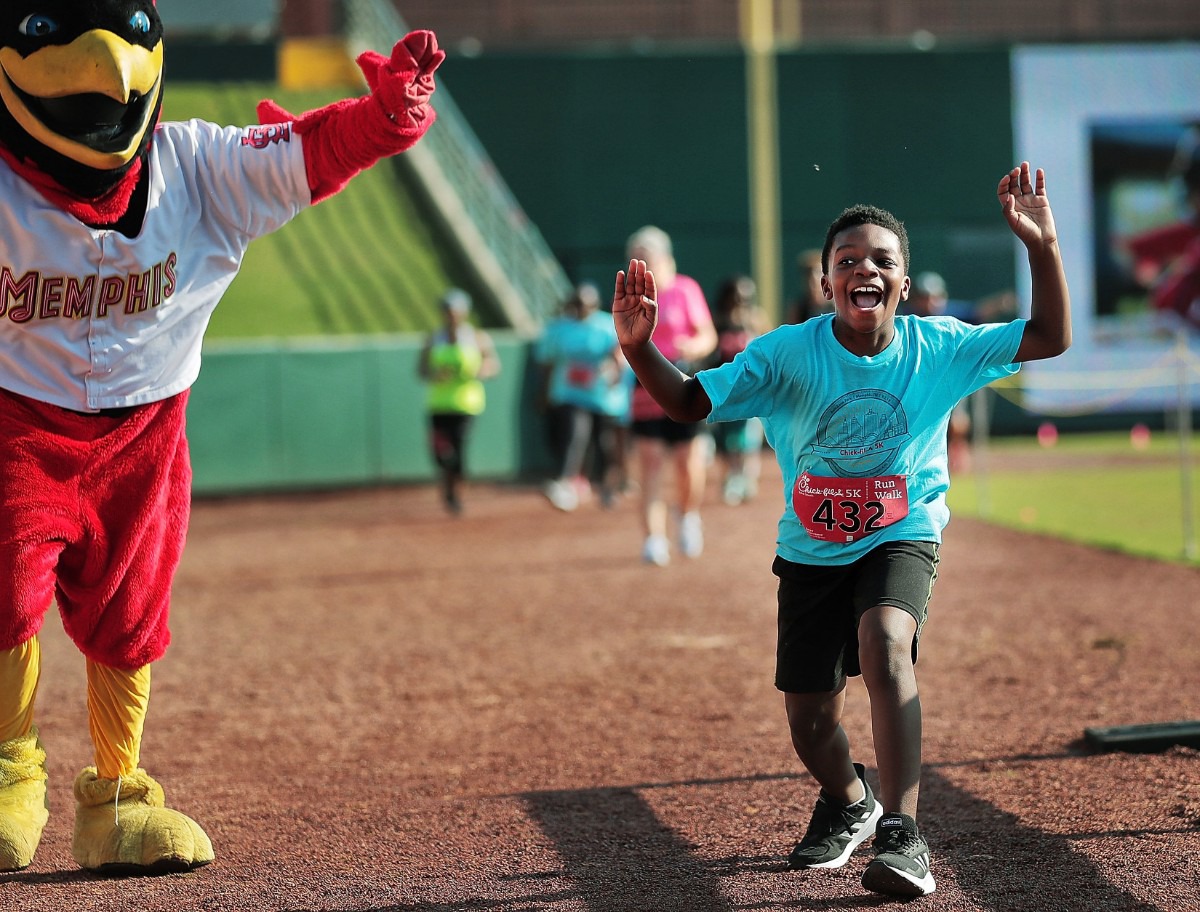 <strong>Michael Lowe, 10, flaps along with Rocky the Redbird on the final stretch as he finishes the 17th Annual Chick-fil-A 5K at AutoZone Park benefiting Junior Achievement on September 2, 2019.</strong> (Jim Weber/Daily Memphian)