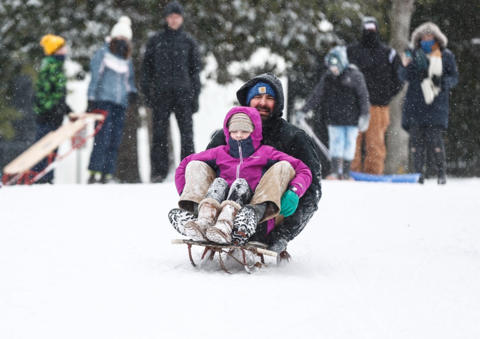 <strong>Daniel O&rsquo;Grady and Emmelia Finley sled in Overton Park as snow falls Jan. 15, 2024.</strong> (Mark Weber/The Daily Memphian file)