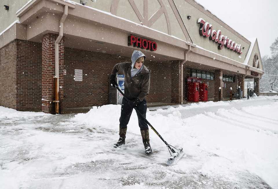 <strong>Jake Grant clears snow-covered sidewalks at the Walgreens on Poplar Avenue near Highland Street on Jan. 10.</strong> (Mark Weber/The Daily Memphian)